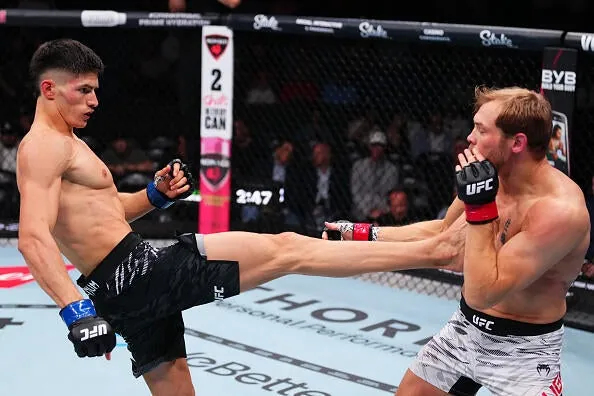 Islam Dulatov of Russia kicks Adam Fugitt in a welterweight bout during the UFC 318 event at Smoothie King Center on July 19, 2025 in New Orleans, Louisiana. (Photo by Cooper Neill/Zuffa LLC)